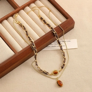 Detailansicht der Vintage Doppel-Halskette mit braunem Tigerauge-Stein und Ledergeflecht