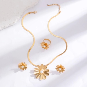 Detail view of gold flower jewelry set with daisy petals, pearls and flat snake chain
