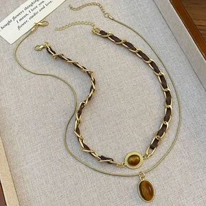 Nahaufnahme der doppellagigen Tigerauge-Halskette mit Goldkette und Lederband