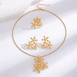 Detail of gold flower jewelry set featuring brushed petals on necklace and earrings