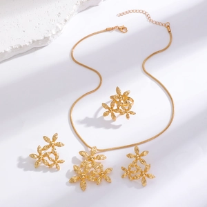 Macro shot of gold floral jewelry set with textured petals and elegant necklace chains