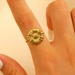 Macro shot of a golden sunflower ring with textured petals and floral design on finger
