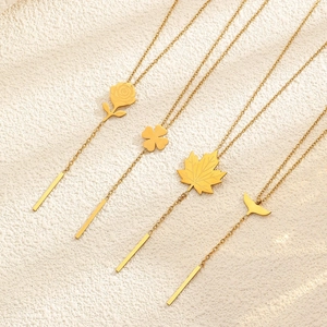 Detail showing four gold floral tassel necklaces with rose and maple leaf pendants