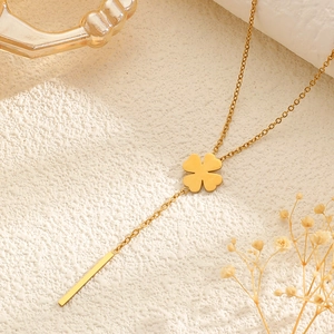 Detail of 18k gold plated stainless steel Y-shaped necklace with clover and bar pendants