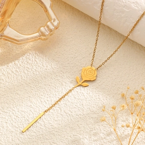 Detailed macro view of 18k gold plated stainless steel rose pendant and tassel chain