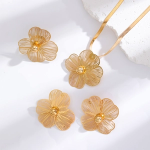 Detailed view of golden hollow flower jewelry set with intricate petal texture and snake chain