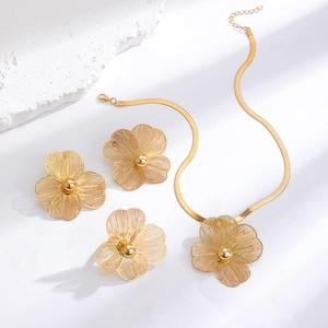 Detailed view of golden hollow floral jewelry set featuring necklace ring and earrings