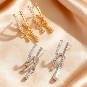 Makroaufnahme eleganter Tropfenohrringe in Gold und Silber mit Zirkonia-Verzierung