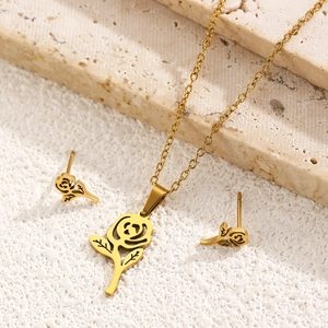 Close-up of hollow rose flower tassel pendant and earrings in 18k gold-plated steel