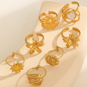 Detailed macro view of 7-piece gold flower ring set with sunflower and daisy designs
