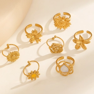 Flat lay of multiple 18k gold plated stainless steel floral rings with shell details