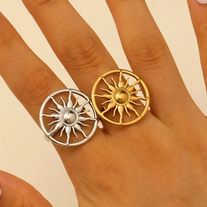 Close-up of gold and silver sunburst cutout rings on fingers in polished finish