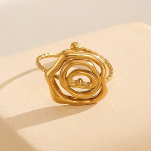 Detailed close-up of matte gold flower ring with hammered texture on stone base