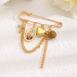 Détail d'une broche vintage dorée avec pendentif croix et portrait religieux de Marie