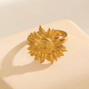 Macro view of 18k gold plated stainless steel sunflower ring on beige stone stand