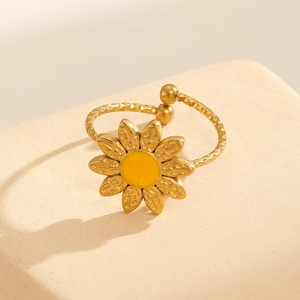 Macro detail of 18k gold plated sunflower ring featuring yellow enamel and wavy textured band