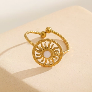 Detail of 18k gold plated sun totem ring with white stone and hammered texture band