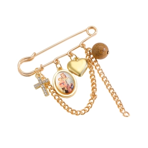 Vue détaillée de la broche vintage avec croix, breloques cœur et pendentif religieux