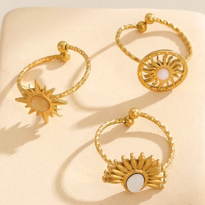 Macro detail of three 18k gold plated sun motif rings with hammered texture and stones