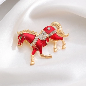 Detailaufnahme einer Brosche in Pferdeform mit roter Emaille und glänzenden Strasssteinen