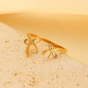 Detailed close-up of a 18k gold plated open ring with dual bowknot design on stone