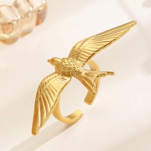 Macro shot of 18k gold stainless steel open ring featuring a detailed flying bird wing design