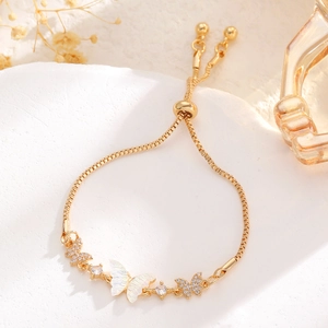 Detail of adjustable gold butterfly bracelet with mother of pearl and pavé stones
