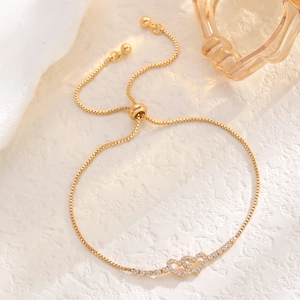 Detailed macro of golden double heart bracelet with cubic zirconia and adjustable slide closure