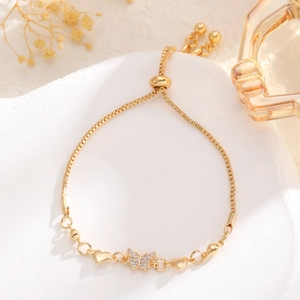 Detail of adjustable gold bracelet featuring a crystal butterfly and heart charms
