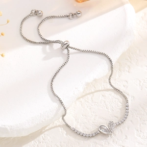 Macro detail of adjustable box chain bracelet with heart-shaped crystal pendant