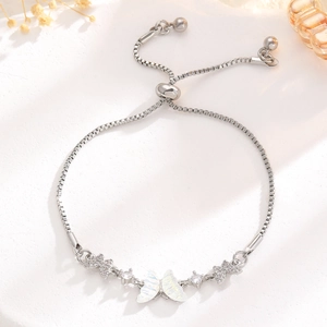 Detail of adjustable silver butterfly bracelet with shell texture and sparkling stones
