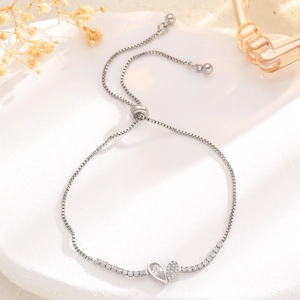 Detail of silver heart charm bracelet with sparkling zircons and adjustable slider