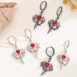 Gothic Vampir Ohrringe Set mit roten Herzsteinen und Fledermausflügeln auf Hintergrund