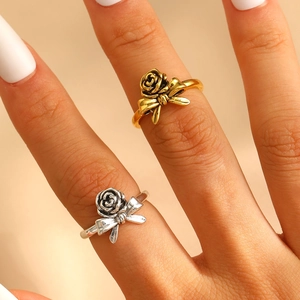 Macro view of vintage style gold rose and ribbon bow open ring on finger detail