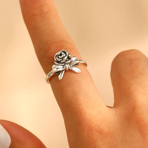 Close-up of vintage silver rose ring with bow tie detail worn on a model's finger