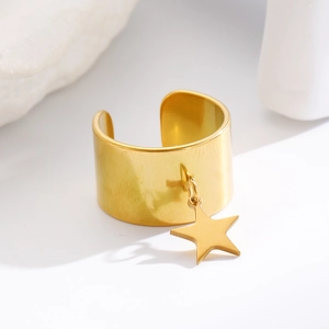 Dettaglio di un anello largo dorato stile vintage con ciondolo a stella e finitura lucida