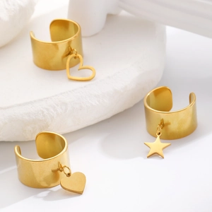 Dettaglio macro di ear cuff in acciaio inossidabile dorato con ciondoli a cuore e stella