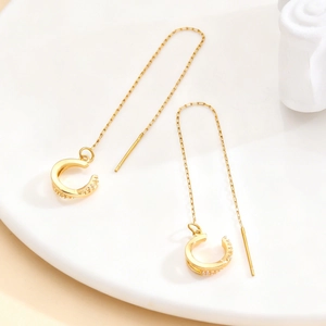 Golden C-shaped tassel cuff earrings with white zircon accents in a long chain design