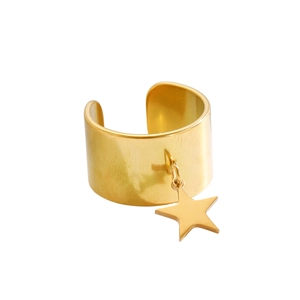 Dettaglio di un anello largo dorato con un ciondolo a stella sospeso su sfondo bianco