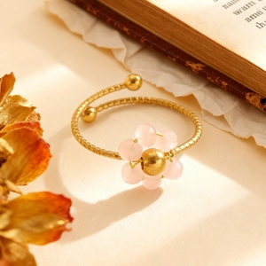 Detail eines rosa Kristall-Blumenrings mit handgehämmerter goldfarbener Metallstruktur