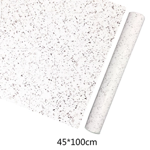 Detail of self-adhesive white terrazzo wallpaper roll showing stone texture pattern 45x100cm