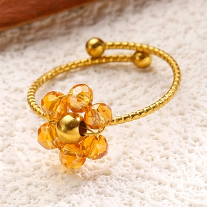 Makroaufnahme eines verstellbaren Goldperlenrings mit facettierter Bernstein-Kristallblume