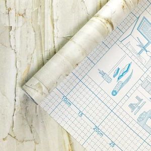 Détail du papier peint marbre adhésif avec marquages de découpe sur le support
