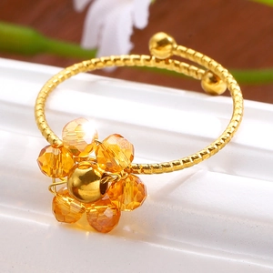 Makroansicht Goldener Blumenring mit orangefarbenen Bernsteinperlen und Spiralkette