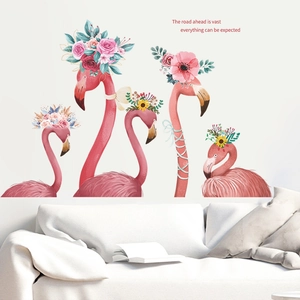 Pink flamingo wall stickers with floral crowns above a white sofa in a modern living room