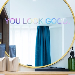 Holographic laser 'YOU LOOK GOOD' lettering wall sticker on a gold-framed round mirror
