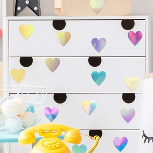 Adesivi murali a cuore olografici con finitura laser iridescente su mobili bianchi