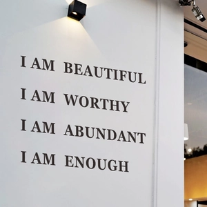 Minimalist black adhesive wall stickers with positive quotes I AM WORTHY under a lamp