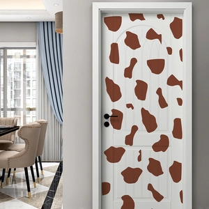 Detail of self-adhesive giraffe pattern wall sticker applied on a white interior door