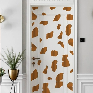 Close-up of artistic brown giraffe pattern wall stickers on a white modern door